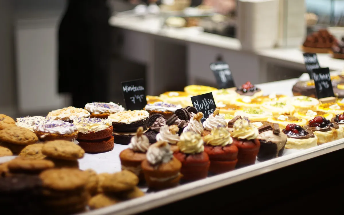 Muffins and pastries seen through a shop window