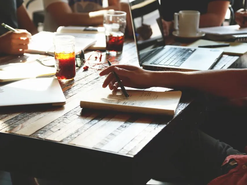 A team working at a table with laptops and notebooks