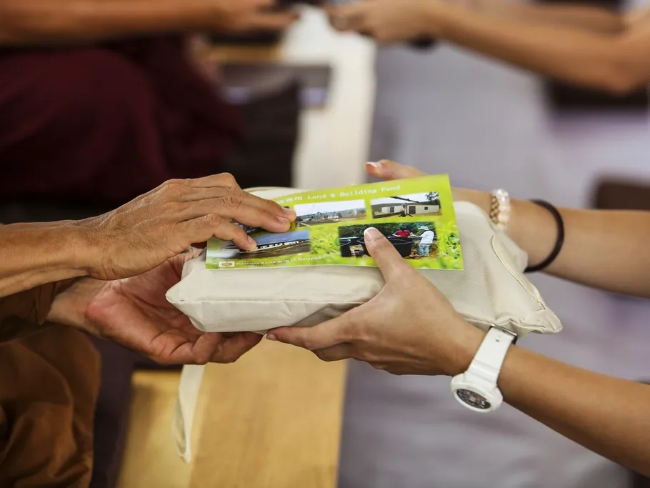 Hands passing a donated food parcel