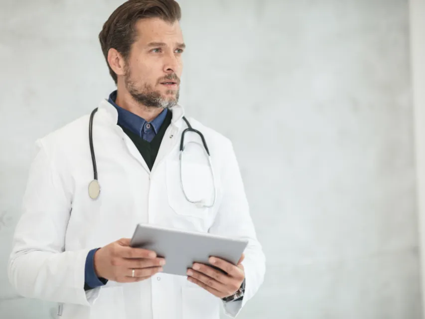 Doctor with a stethoscope reading a tablet