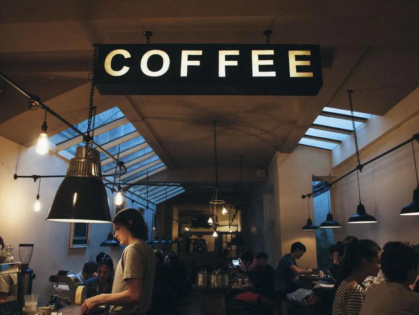 Coffee shop counter under a lit coffee sign