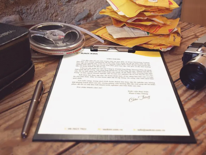 A signed contract on a clipboard with a pen