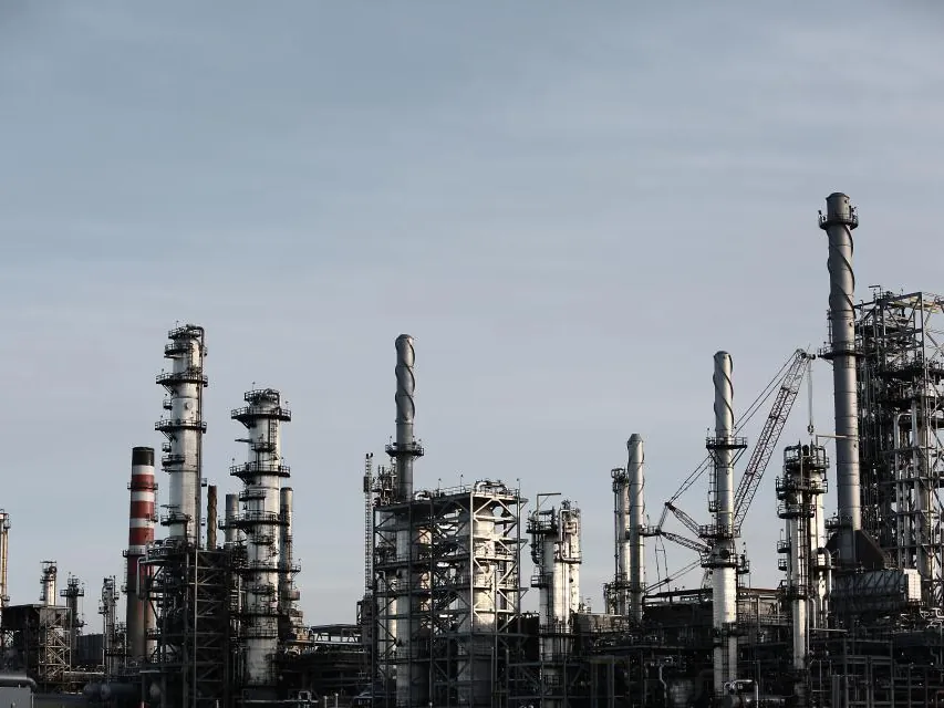 Industrial plant towers against a grey sky