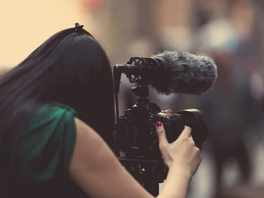 Videographer filming with a camera and microphone