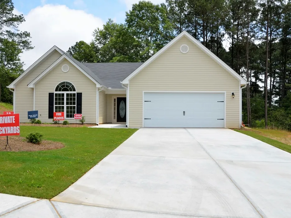 A single family house with a sale sign on the lawn